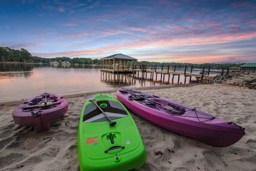 Kayaks on a sandy beach at StayLakeNorman luxury waterfront vacation rental home in Lake Norman, North Carolina. 