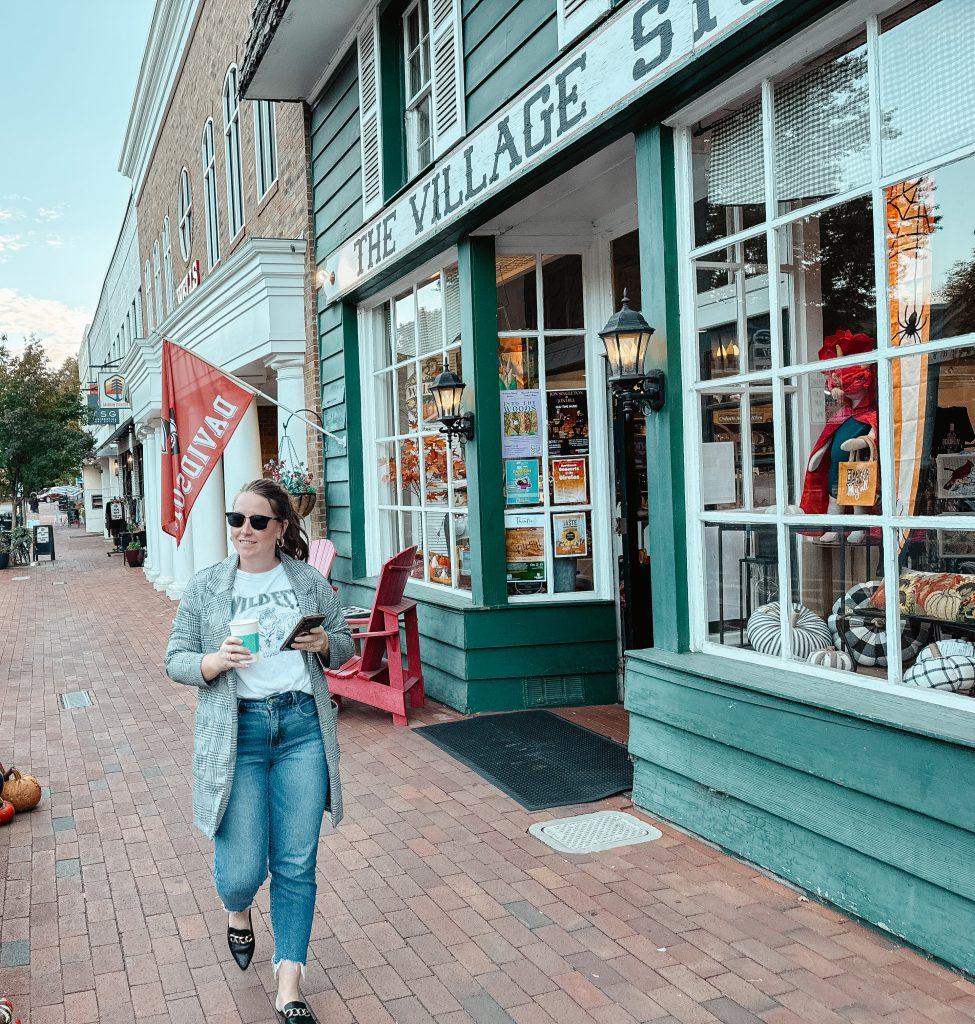 Woman walking past shops in downtown Davidson, NC