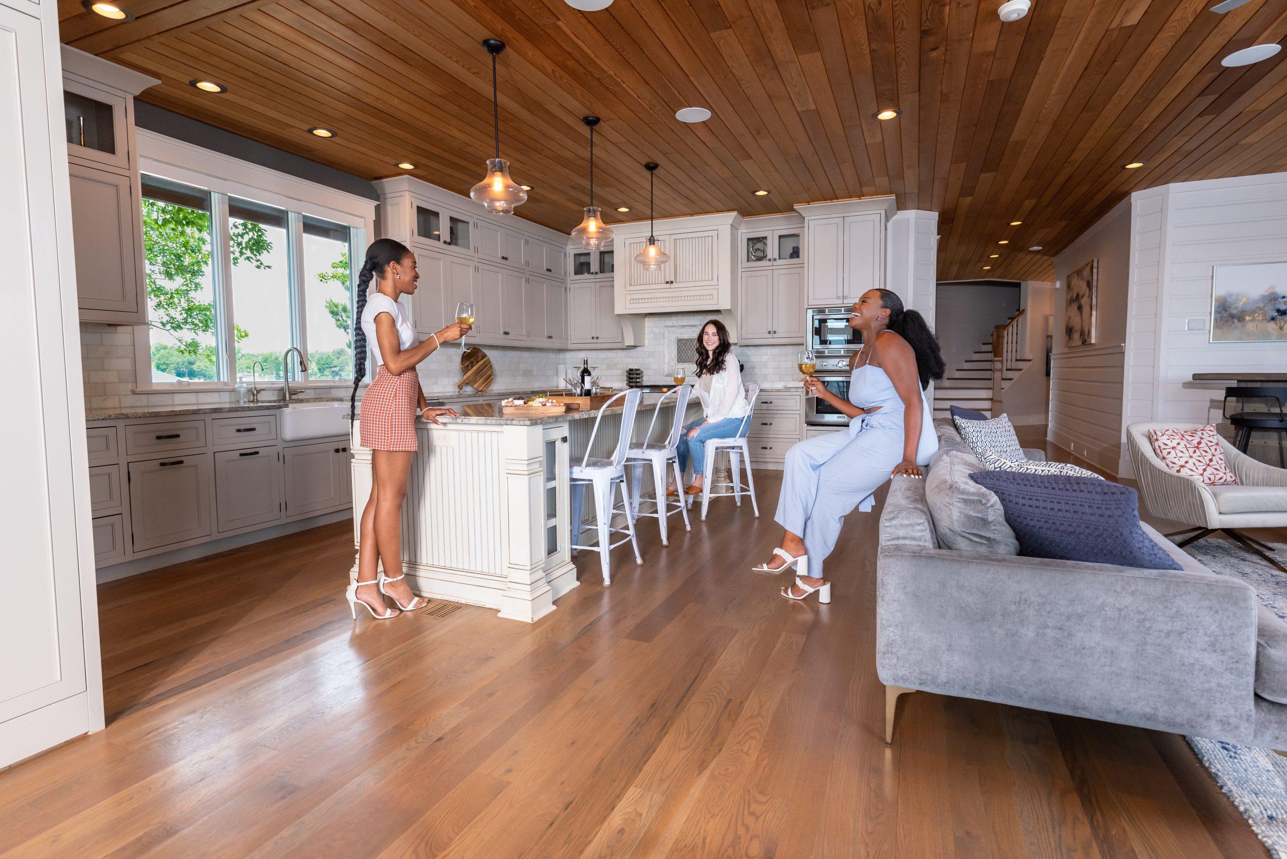 three people gathered in open concept kitchen at StayLakeNorman vacation rental, The Chasestone.
